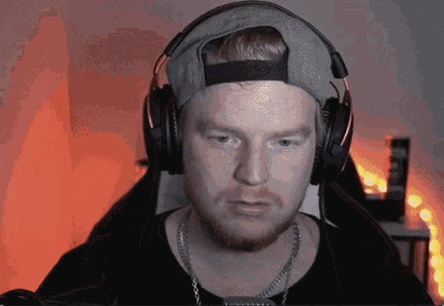 a man wearing a hat and headphones looks at the camera