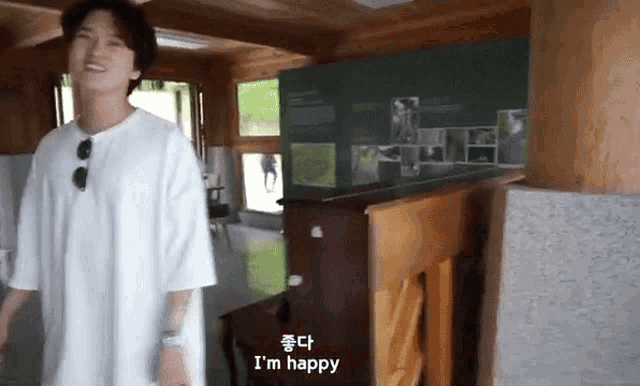 a man in a white shirt says i 'm happy in a room