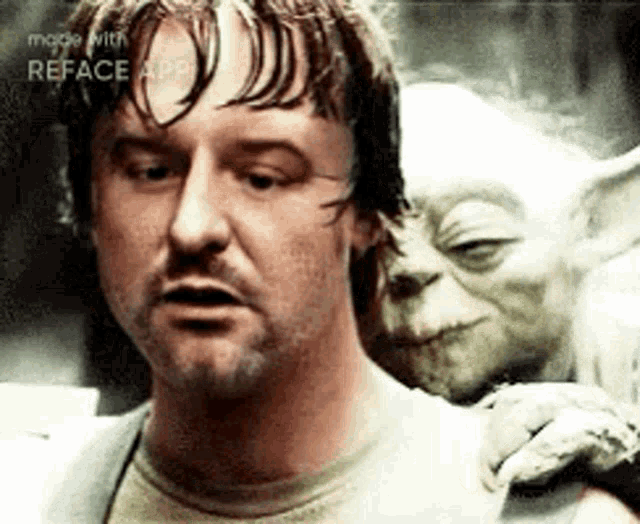 a man with a beard is standing next to a green alien .