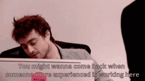 a man is sitting in front of a laptop with the words you might wanna come back when someone more experienced is working