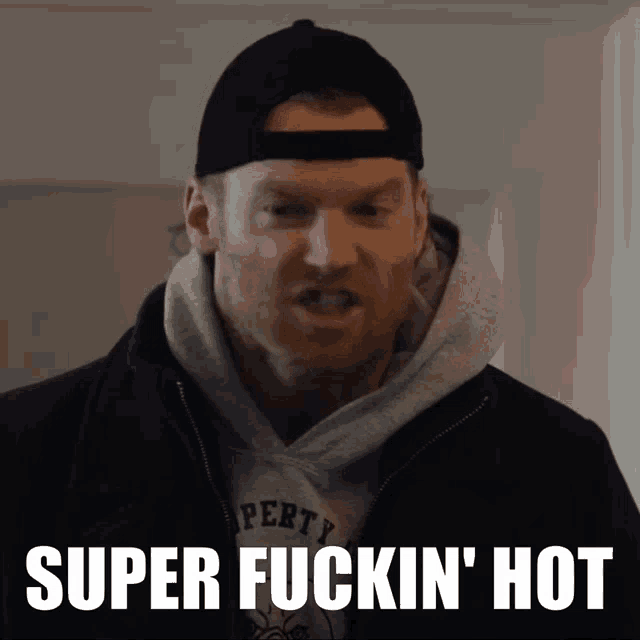 a man wearing a black hat and a grey hoodie with the words super fuckin ' hot on the bottom
