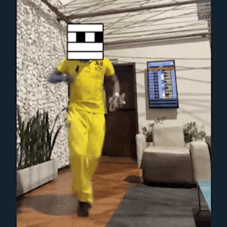 a man in a yellow polo shirt and yellow pants is walking in a room ..
