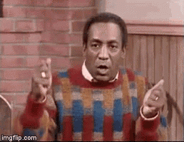 a man in a plaid sweater is pointing at something with his fingers .