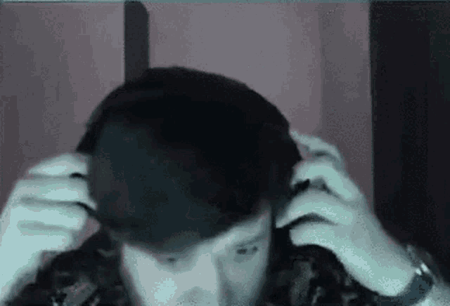 a man with a beard is wearing headphones and looking at the camera .