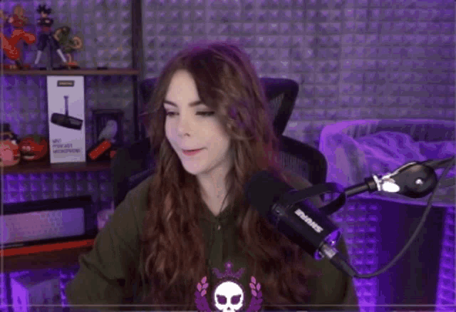 a woman is sitting in front of a shure microphone in a room .