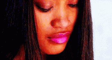 a close up of a woman 's face with pink lipstick and her eyes closed .