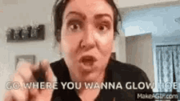 a woman is pointing at the camera and saying `` go where you wanna glow , '' .