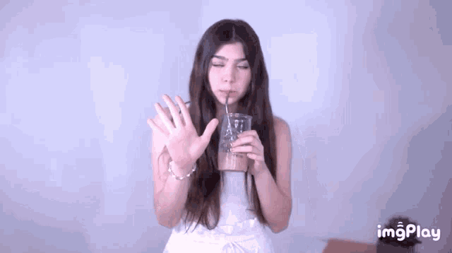 a woman drinking from a cup with a straw and the word imgplay on the bottom right