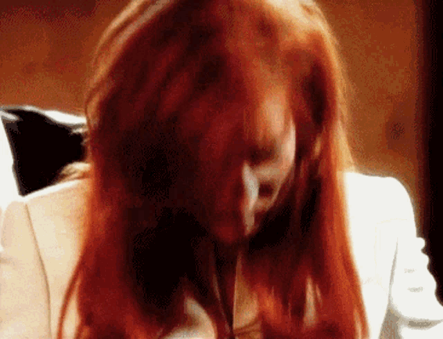 a close up of a woman 's head with red hair