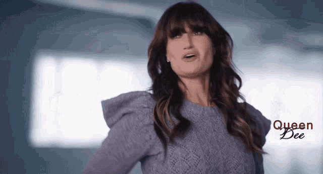 a woman is wearing a purple sweater with queen bee written on the bottom