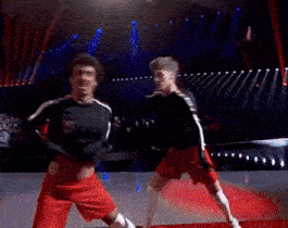 a man in a black shirt and red shorts is fighting another man in a black shirt and red shorts