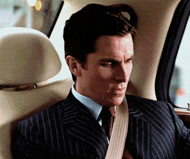 a man in a suit and tie is sitting in a car
