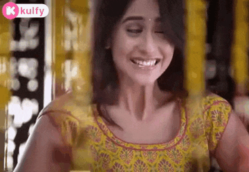 a woman in a yellow dress is smiling with her eyes closed and looking at the camera .