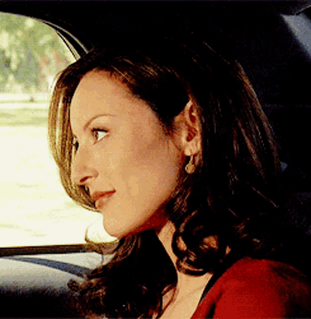 a woman is sitting in the back seat of a car and looking out the window