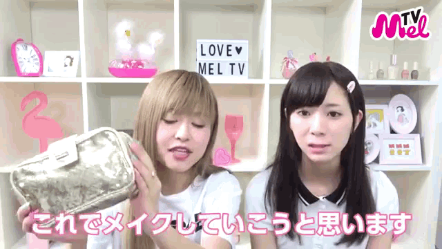 two girls are standing in front of a shelf that says love mel tv