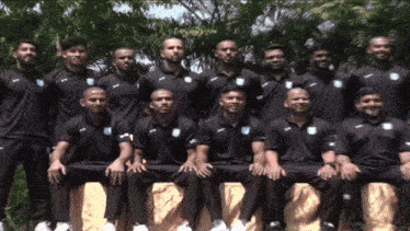 a group of men are posing for a picture and one of them is wearing a shirt that says ' uc ' on it