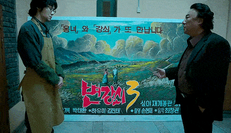 two men standing in front of a painting that says 3
