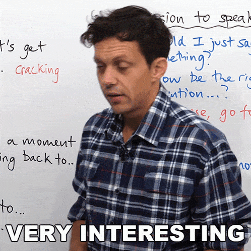 a man in a plaid shirt is standing in front of a whiteboard that says very interesting