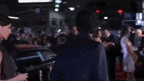 a man and a woman are standing in a crowd of people .