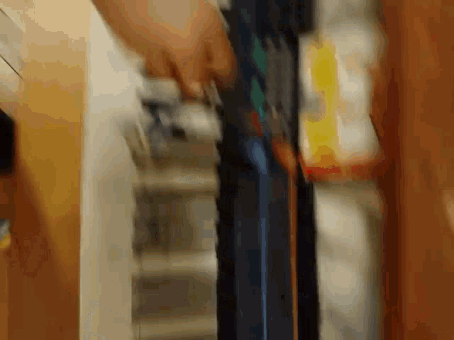 a close up of a person 's hand opening a door in a kitchen
