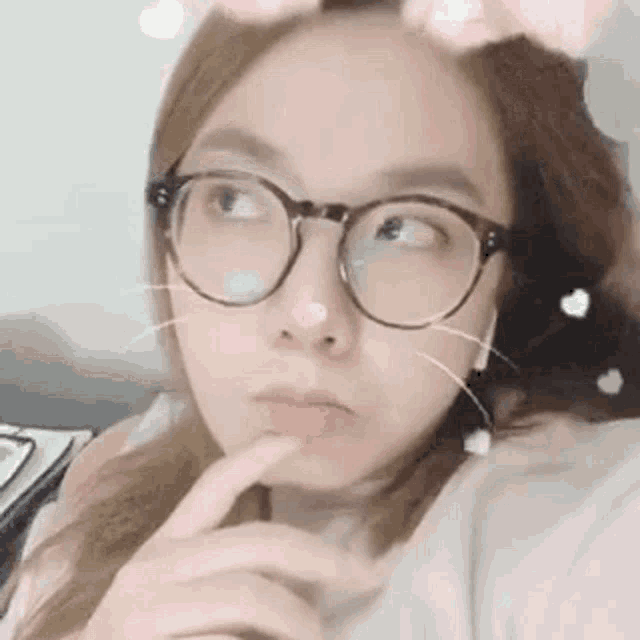 a close up of a woman wearing glasses and a cat face filter .
