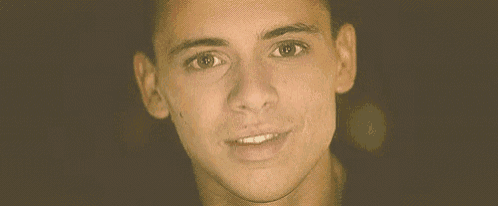 a close up of a young man smiling with his mouth open .