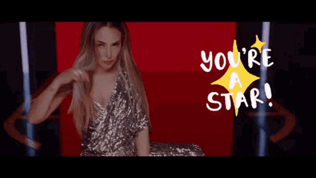 a woman in a sequined dress is sitting on a red couch with the words you 're a star above her