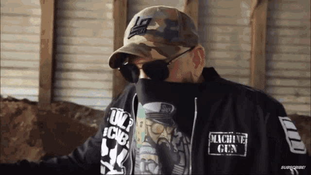 a man wearing sunglasses and a machine gun hoodie