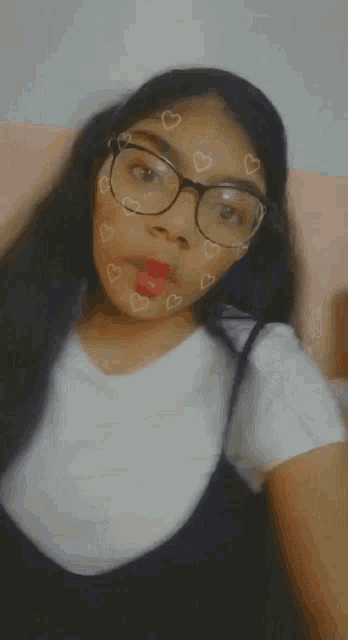 a girl wearing glasses and a white shirt with hearts on her face