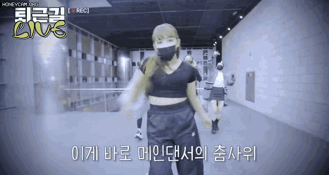a woman wearing a mask is dancing in front of a camera with the words live in the corner