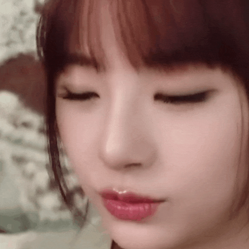 a close up of a woman 's face with her eyes closed and her mouth open .