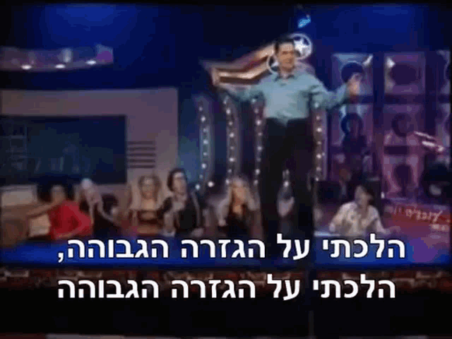 a man is standing on a stage in front of a crowd of people .