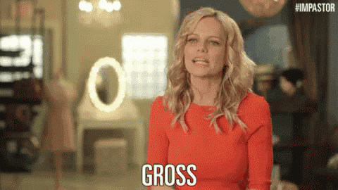 a woman in a red dress is standing in front of a mirror and says gross .