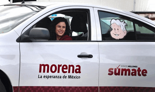 a woman is sitting in the driver 's seat of a white morena car