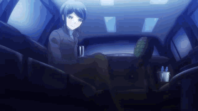 a girl is sitting in the back seat of a car holding a cup of coffee .