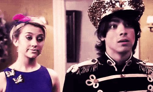 a woman in a blue dress is standing next to a man in a military uniform with 88 on his sleeves