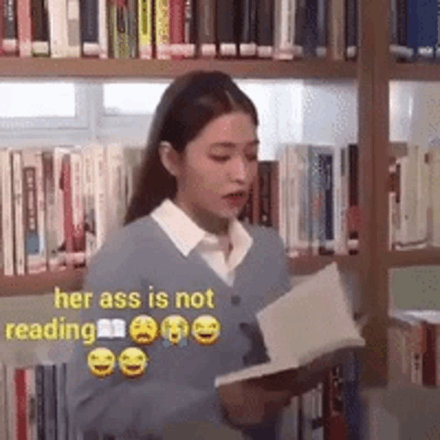 a woman is reading a book in a library with the caption her ass is not reading .