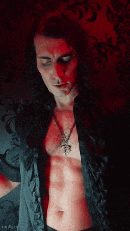 a man in a black shirt with a caduceus necklace around his neck