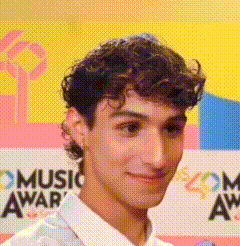 a man stands in front of a music awards sign