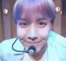 a close up of a person with purple hair wearing a microphone .