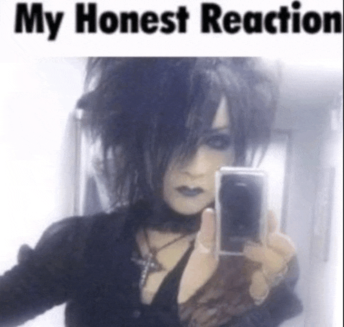 a goth girl taking a selfie with the words my honest reaction below her
