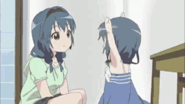 two anime girls are sitting next to each other in a room and talking .
