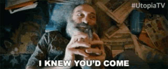 a man with a beard is smoking a cigar and saying i knew you 'd come .