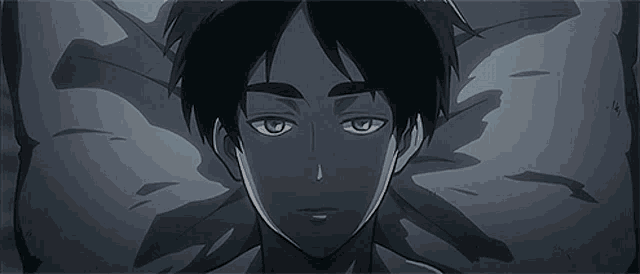 a close up of a young man laying on a bed .