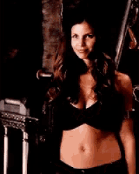 a woman in a black bra is standing next to a railing and smiling
