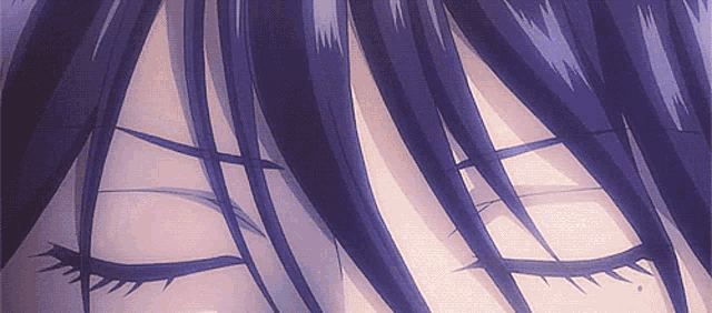 a close up of a person 's eyes with purple hair .