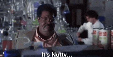 a man in a suit and tie is sitting at a bar talking about nuts .