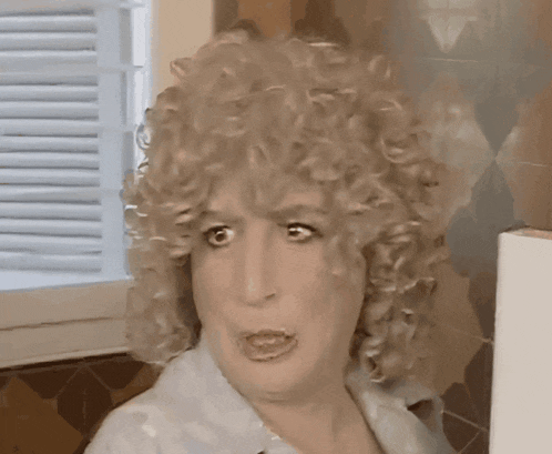 a woman with blonde curly hair is making a funny face