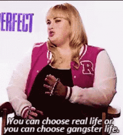 a woman in a pink varsity jacket is sitting in a chair talking .