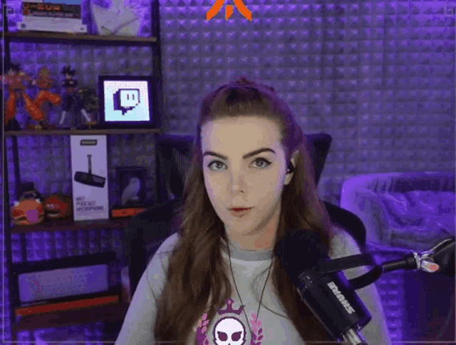 a woman is sitting in front of a microphone in a room with a purple wall .